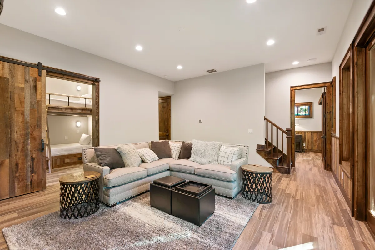 A spacious and cozy sectional sofa complemented by coffee tables and a wooden sliding door, providing an ideal setting for group gatherings, storytelling, or board game sessions in a relaxed atmosphere.