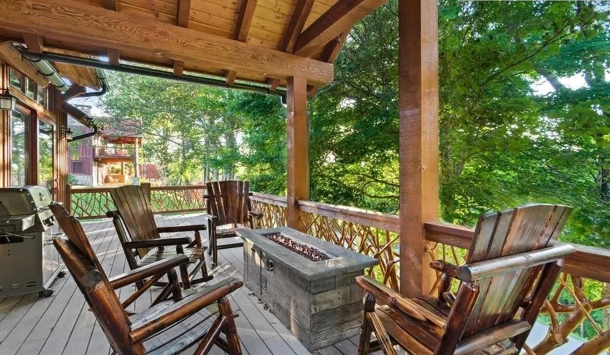 A cozy fire pit area with wooden chairs and surrounding natural greenery, designed for outdoor relaxation, s’mores, and storytelling under the evening sky.